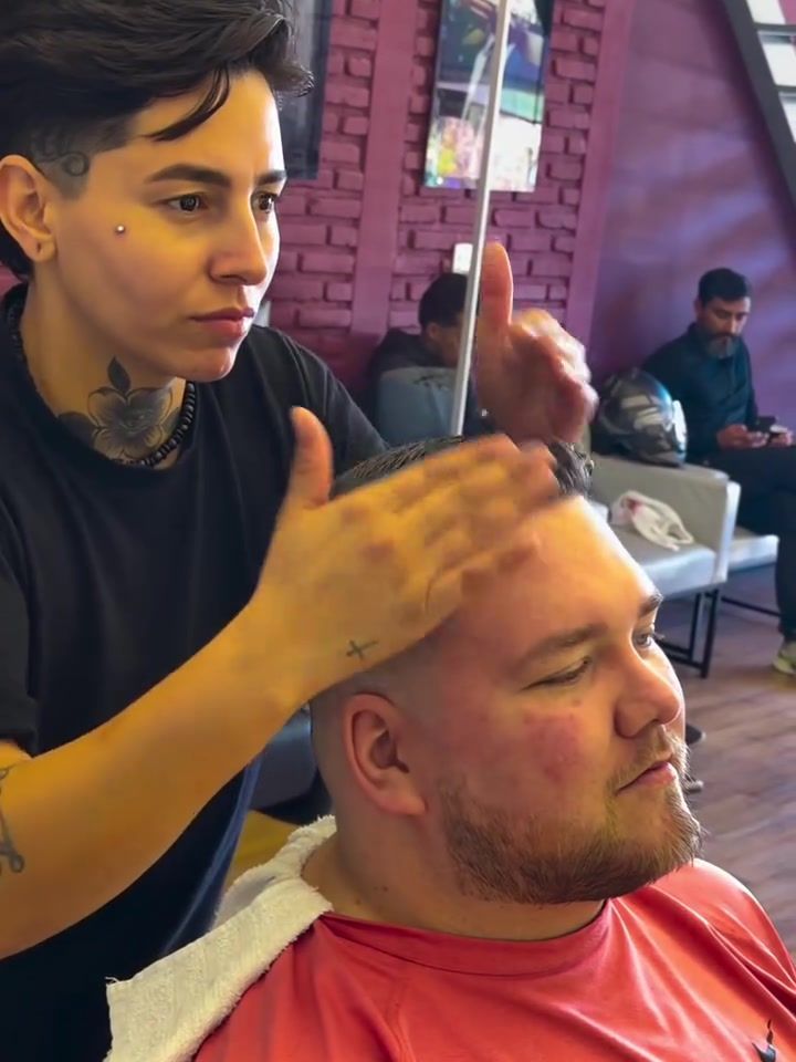 Barbeira ajeitando o cabelo do cliente na cadeira
