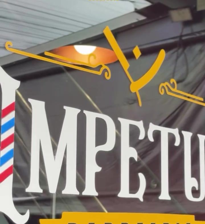 Mural com o letreiro Impetus Barbearia pintado na parede